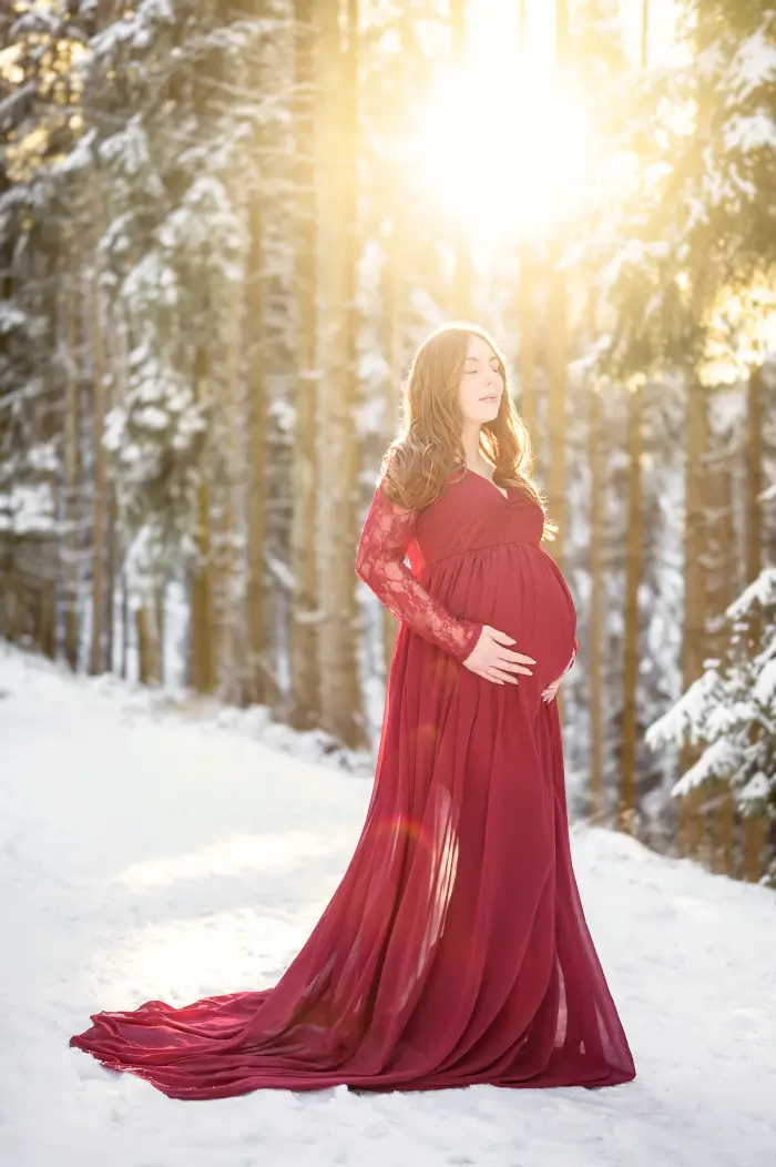 Photographe de grossesse à Saint-Geoire-en-Valdaine près de Voiron, Tullins et Grenoble | Photo de grossesse, lifestyle, femme enceinte de côté en robe rose avec magnolia fleurs roses et rayon de soleil
