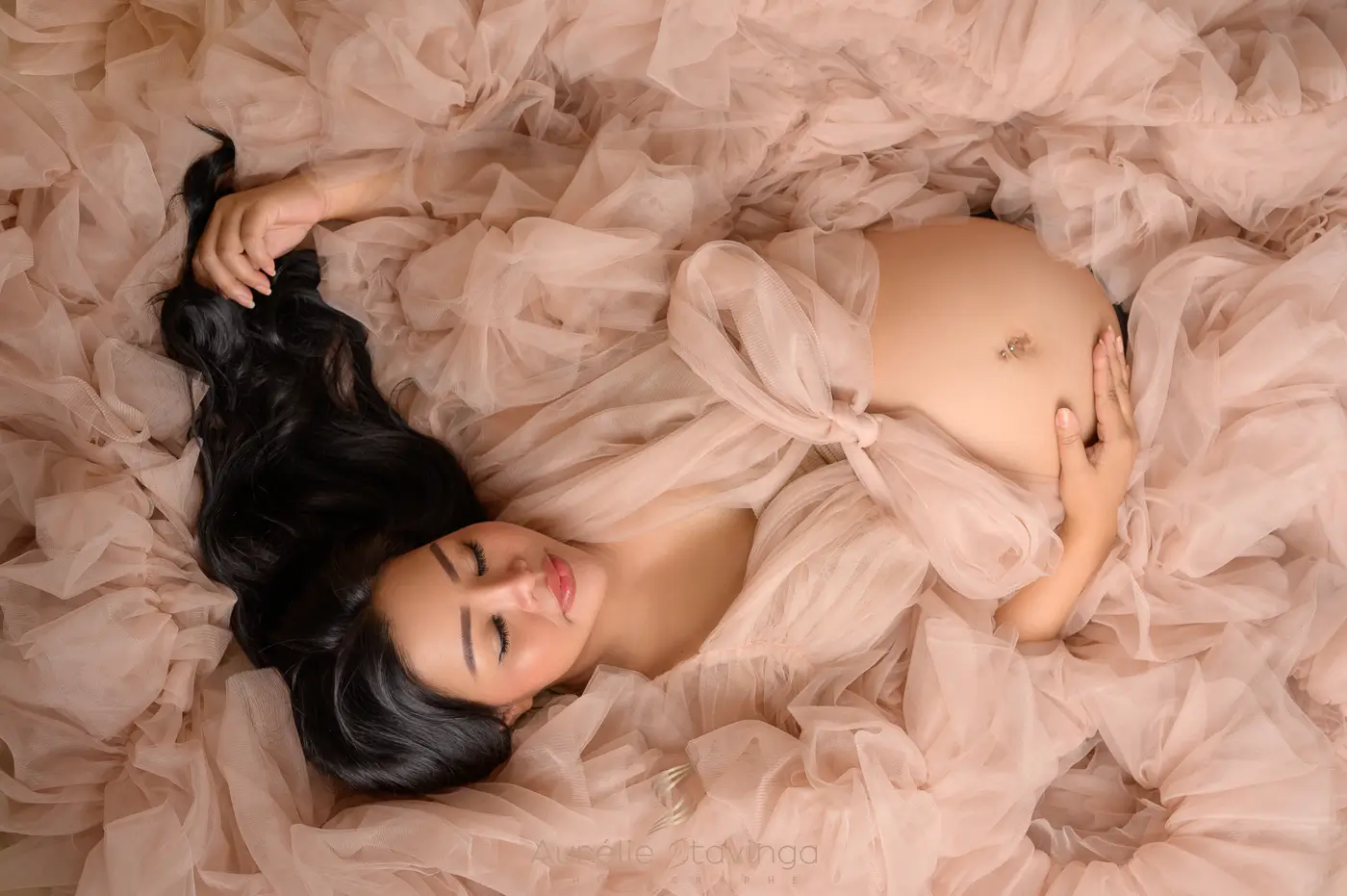 Photographe de grossesse à Saint-Geoire-en-Valdaine près de Voiron, Tullins et Grenoble | Photo de grossesse, lifestyle, femme enceinte de côté en robe rose avec magnolia fleurs roses et rayon de soleil